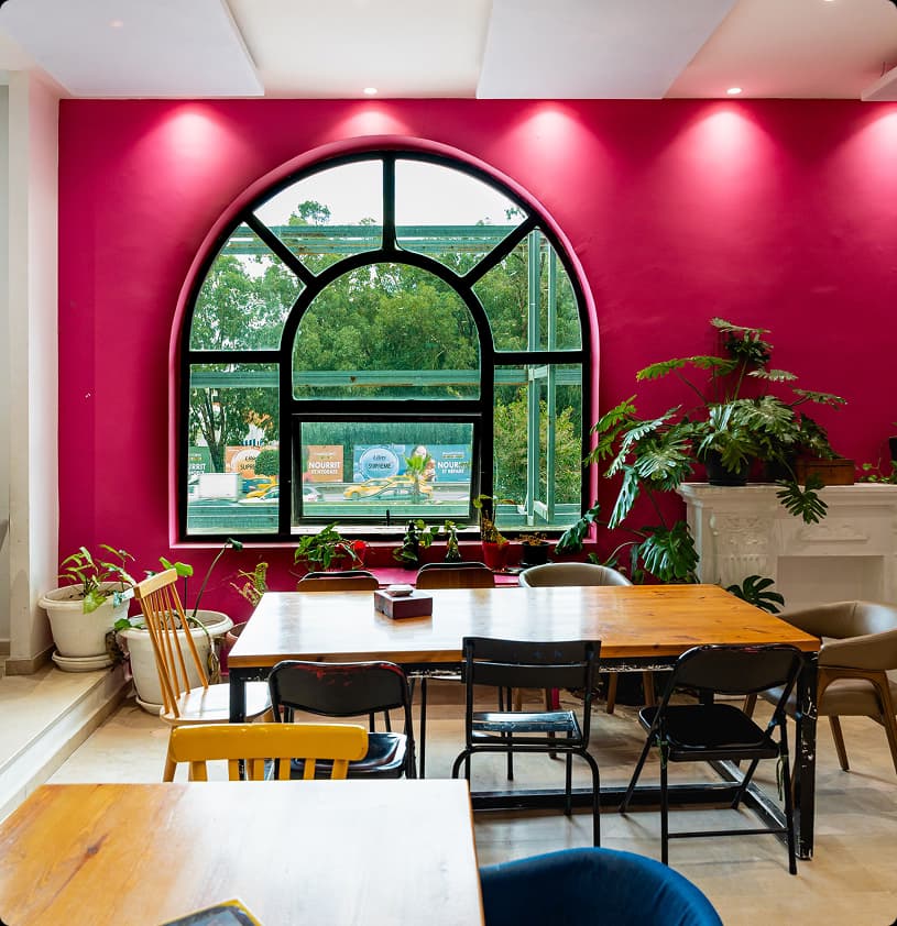 Cafe interior with pink walls and arched window